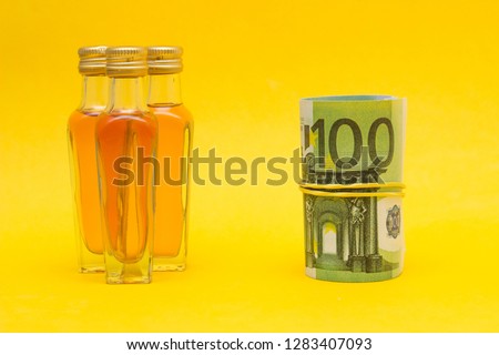 Small bottles with alcohol and euro money, income from the alcohol trade, price increase, close-up
