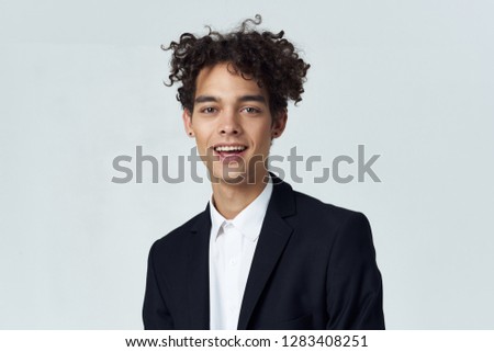 Curly man in shirt and jacket on a light background       