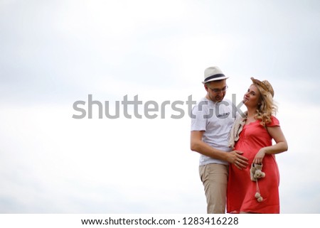 Pregnant girl with big belly and young man in park
