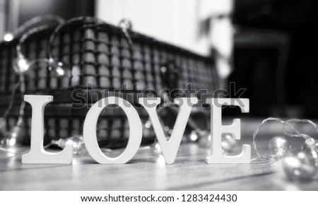 the word love made up of white wooden letters on a wooden background