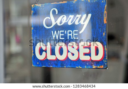 Hanging closed sign on door of store showcase