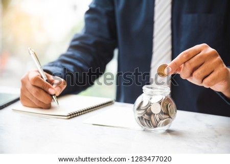 Close up businessman accounting with coins in glass on the table. Saving money concept, Finance money concept, Investment concept