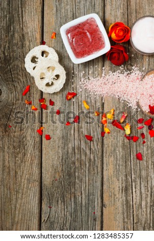 facial mask and moisturizer with roses on weathered wooden