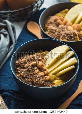 Cozy morning concept with turmeric amaranth porridge served with apples, flax seeds and almonds. Healthy plant based vegan breakfast. Flat lay