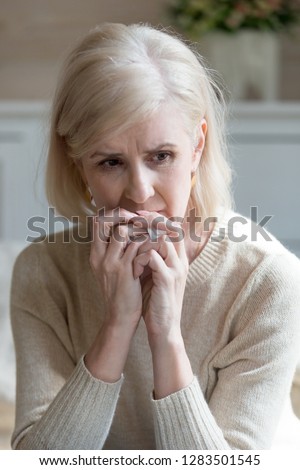 Vertical view image of blond caucasian upset middle aged sixty years woman holding handkerchief in hand sitting alone at home feels unhappy unwell miserable and anguishes mature woman mourns spouse Royalty-Free Stock Photo #1283501545