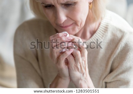 Unhappy middle aged woman folding hands together holding handkerchief crying feels bad and miserable, close up image. Sad life circumstances, death of relative person and terminal illness concept Royalty-Free Stock Photo #1283501551