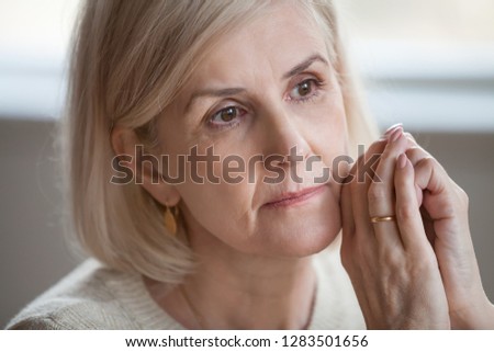 Close up face grey haired woman looking away. Portrait of distracted female thinking about problems remembering moments of life she misses her children and grandchildren feeling loneliness and sadness Royalty-Free Stock Photo #1283501656