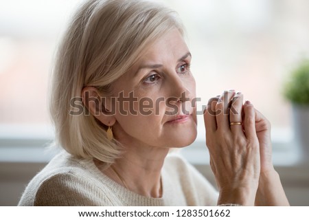 Close up portrait of beautiful sad woman folding hands together near her face, thinking about life. Aging is period of physical decline and senile dementia, mental disorders emotional problems concept Royalty-Free Stock Photo #1283501662