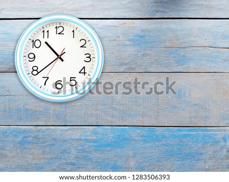 Wall clock (white-blue) on painted wooden walls. 
Looked simple and copy space.