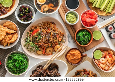 Assortment of Chinese food on white table Royalty-Free Stock Photo #1283529664