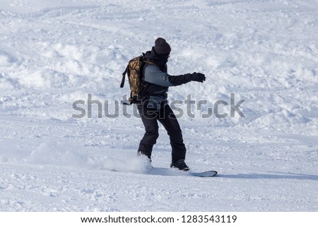 A man snowboarding a mountain in the snow in winter .