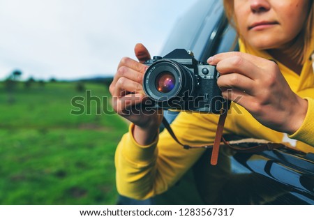 smile tourist girl in an open window of a auto car taking photography click on retro vintage photo camera, photographer looking on camera technology, blogger using hobby content concept, enjoy trip