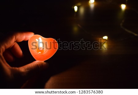 close up candle heart in hand of women,love concept