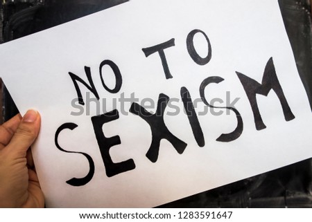 White sheet with the inscription No to Sexism glued to a black board.