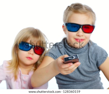 Studio shot of two girls in 3d glasses with control panel watching TV. Focus on the control panel. Isolated white background