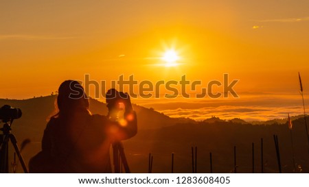 silhouette landscape at morning time tourist take pictures of the sunrise and mist on the mountain chiang rai Thailand