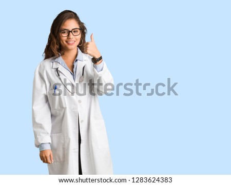Full body young doctor woman smiling and raising thumb up