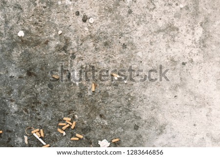 The cigarette butts background. Royalty high-quality stock photo image of dirty  cigarettes butt on the pavement street. A lot of burnt cigarette butts with some ash with copy space for text design