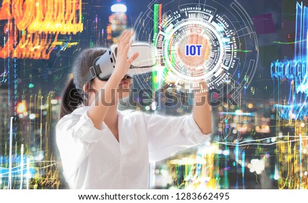 Asian Woman student wearing vr virtual reality interaction headset over technology digital screen. Smart City IOT network background for learning new simulation sci, Futuristic innovation device ideas