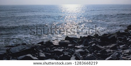 Rock boulders at beach, calm sea are captured in this picture