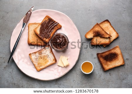 Composition with tasty toasts, chocolate spreading and honey on table