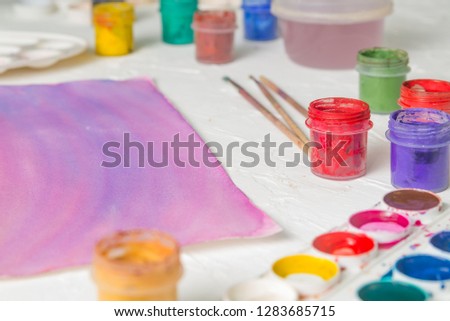 watercolor paints, gouache and brushes for the artist on the background of the drawing copy space