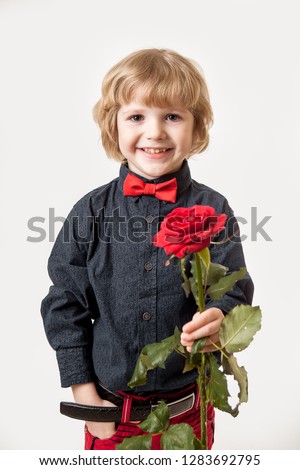 holiday gift. Flowers from a little gentleman. Red rose in the hands of a boy on a white background, is isolated. Valentine's Day.