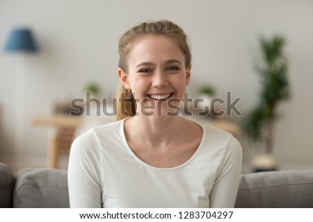 Happy friendly casual teen girl looking at camera, smiling cheerful woman making video blog or call at home, young female vlogger blogger laughing recording new vlog, headshot portrait Royalty-Free Stock Photo #1283704297