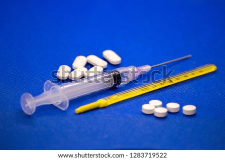 Set of cold medicine and flu virus on blue background.  Antibiotics, homeopathy, pills. Medicine and drug concept.