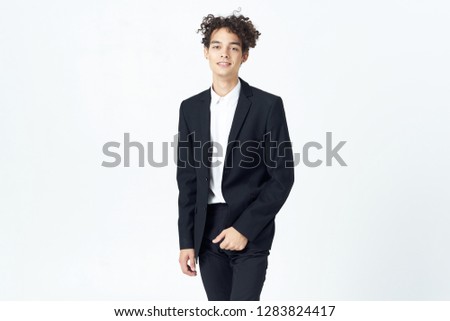 Business man with curly hair in a dark suit on a light background