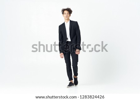 Cute business man in a black suit in full growth