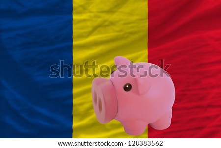Piggy rich bank in front of national flag of romania symbolizing saving and accumulating funds as good financial habit
