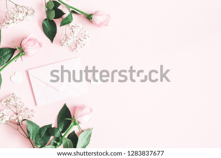 Valentine's Day composition. Pink rose flowers, envelope on pastel pink background. Valentines day, mothers day, womens day concept. Flat lay, top view, copy space