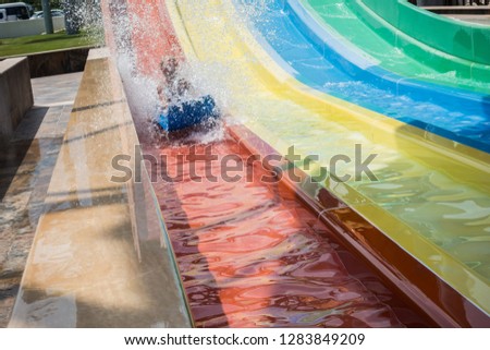 The boy rides a slide in the water park