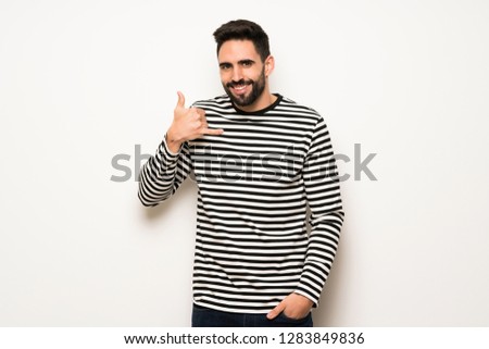 handsome man with striped shirt making phone gesture. Call me back sign