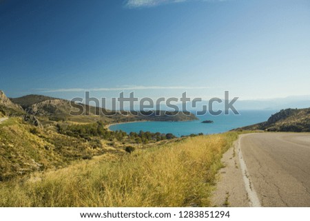 hills highland scenic landscape from above going down with asphalt outskirts country side car road to sea bay shoreline 