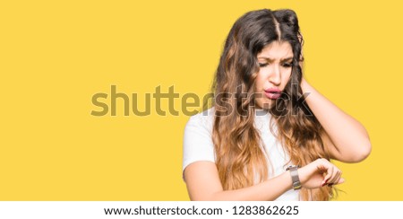 Young beautiful woman wearing casual white t-shirt Looking at the watch time worried, afraid of getting late