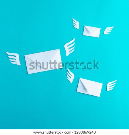Three flying letters from paper, message, mail, sms, blue background, wings, minimalism