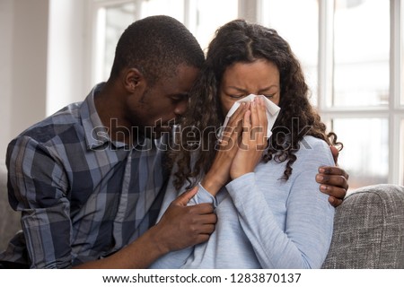 Supportive african husband embracing crying wife asking for forgiveness or consoling comforting helping sharing grief or problem, apology, compassion, empathy in black couple relationships concept Royalty-Free Stock Photo #1283870137