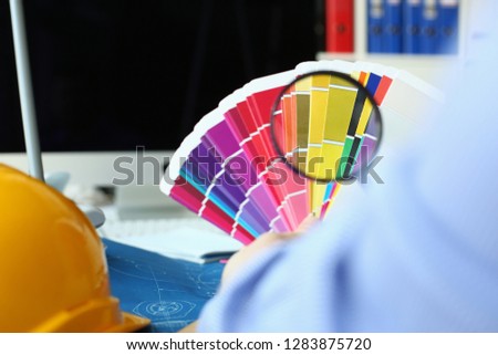 Employee refueling cartridge service holds magnifying glass in hand. Color print of pantone statistics offset organization gives customer an order products for distribution during promotion concept