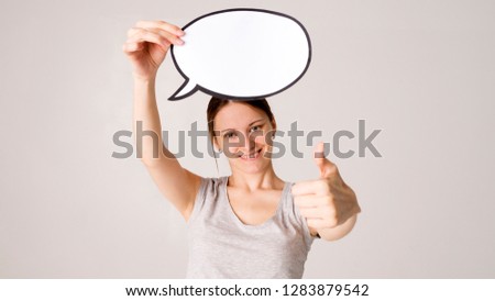 Young woman holding up a speech bubble icon with copyspace