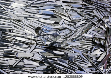 Pile of silver color knives and a spoon as a background
