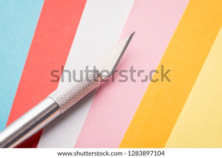 Scalpel for artwork with paper on pages of different colour