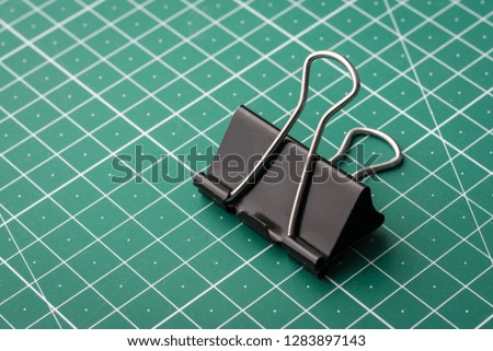 Paper clip on green cutting mat