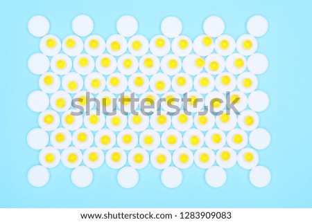 Omega-3 fat yellow capsules on a blue background and white pills.