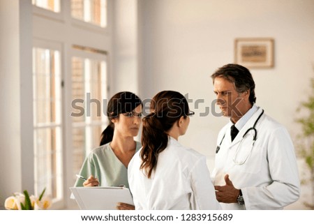 Two doctors and a nurse having a discussion.