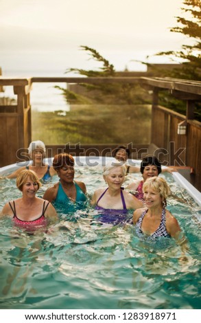 Happy senior women exercising together in a swimming pool.