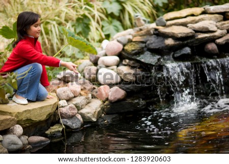 Young girl throwing stone into river