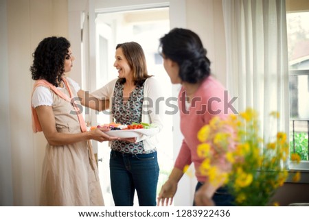 Happy mature woman greeting her neighbors. Royalty-Free Stock Photo #1283922436