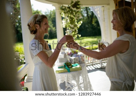 Bride sharing champagne with her mother on her wedding day